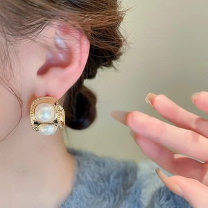 Boucles d'oreilles vintage françaises en forme de C avec perles dorées portées par un modèle