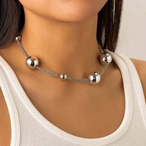 Detail of silver bead pendant and multi-layer chain necklace worn by a fashion model