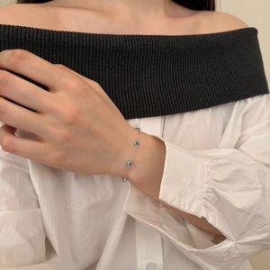 Close-up of S925 sterling silver chain bracelet with blue turquoise round stones on wrist
