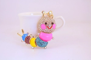 Detail of colorful caterpillar keychain featuring sparkling rhinestones and gold metal