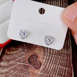 Close-up of heart-shaped silver earrings with sparkling zircon pave setting for women
