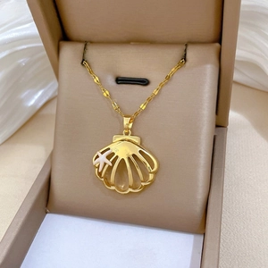 Detailed macro of golden shell pendant with white starfish on soft velvet jewelry box