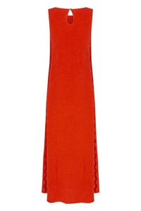Detail of red linen dress showing the scalloped edge stitching and natural fabric texture