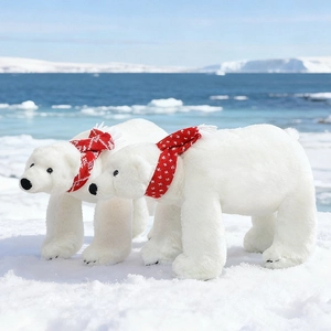 Plush white polar bear toys wearing red scarves standing on realistic arctic snow ice