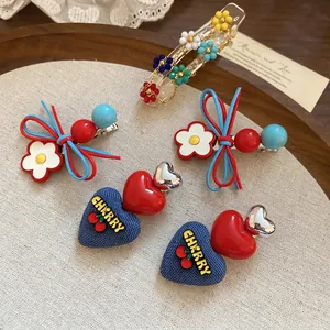 Floral leather bow and denim heart hair clips set displayed on vintage wood