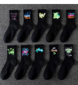 Showcase of ten graffiti style black mid-calf athletic socks with diverse prints