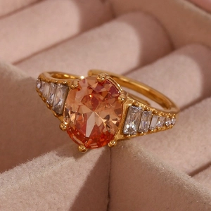 Macro shot of 18K gold plated ring with large oval orange gem and zircon accents