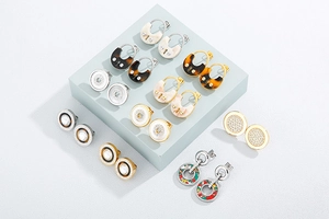 Detail view of gold stainless steel earrings with resin, leopard print and rhinestones