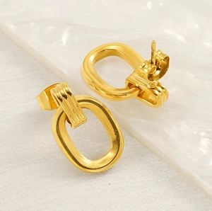 Detailed macro view of gold geometric oval hoop earrings with a polished metallic finish