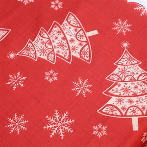 Close-up of red linen Christmas table runner with white snowflake and tree patterns