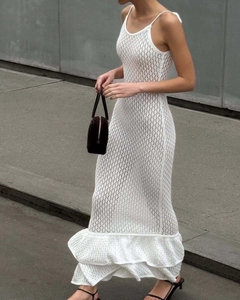 Detaillierte Nahaufnahme von weißem Häkel-Maxikleid mit zarten Rüschen und transparentem Design