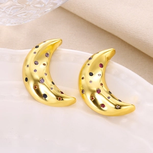 Detail of crescent moon earrings with colorful zircon stones in polished gold finish