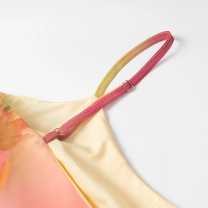 Dettaglio spalline sottili regolabili e tessuto chiffon sfumato rosa e arancione