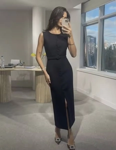 Detail of a black sleeveless midi dress with a waist belt and front slit feature