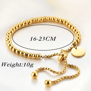 Detailed view of adjustable 18K gold bead bracelet with blank circular tag and slide clasp