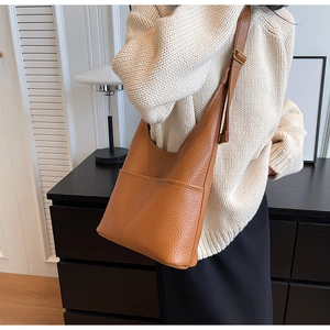Gros plan sur le sac à bandoulière en cuir grainé marron avec sangle réglable