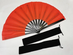Close-up of a red bamboo kung fu fan with two black velvet drawstring carrying pouches