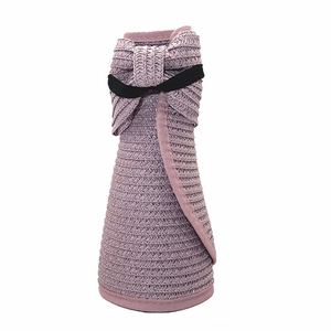 Dettaglio di un cappello da sole pieghevole in paglia lilla con elegante fiocco nero