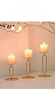 Three-piece set of gold minimalist metal candle holders in various heights for decor