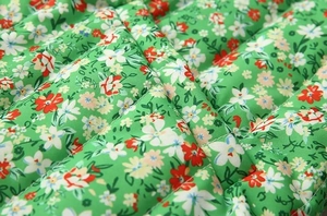 Detailed macro view of diamond quilted stitching on green vintage floral cotton fabric