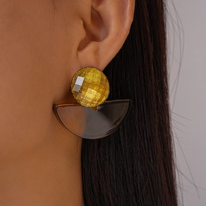Close-up of geometric resin drop earring with brown fan-shaped pendant on model