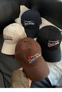 Close-up of baseball caps featuring colorful embroidery and vintage washed cotton texture