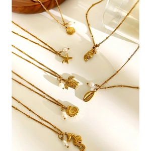 Detailed flat lay of golden ocean themed charms featuring starfish and pearls on bead chains