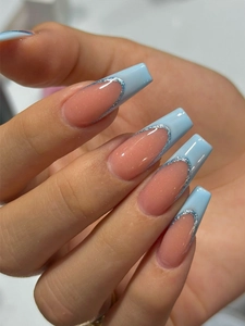 Detailed view of long coffin press-on nails with pink base, blue French tips and glitter