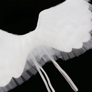 Macro detail of white mesh angel wings with multi-layered ruffled edges and elastic straps