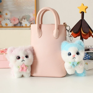 Cute pink and blue plush angel cat keychains with floral collars on a mini handbag