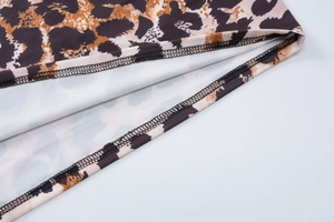 Detailed close-up showing sewing craftsmanship and texture of leopard print fabric garment