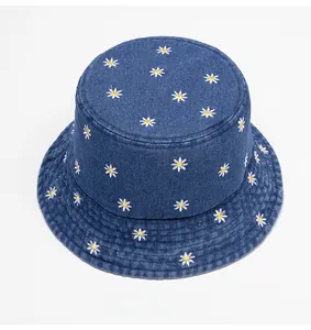 Top view of blue denim bucket hat featuring detailed white daisy floral embroidery detail