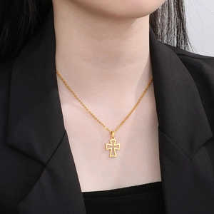 Close-up of minimalist hollow gold cross necklace on neck with black blazer styling