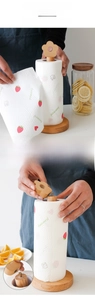 Close-up of wooden kitchen paper holder with a floral knob and polished beechwood base