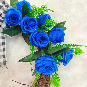 Detail of blue silk roses and plaid bow on a natural grapevine Christmas wreath