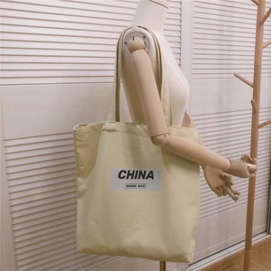 Détail du sac fourre-tout en toile blanc cassé avec motif texte noir China Bounce Back