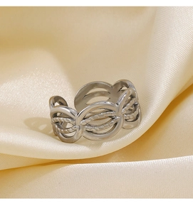 Macro shot of silver woven wave hollow ring on cream satin showing intricate texture