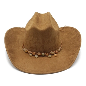 Detail of a brown suede cowboy hat with bohemian beaded band and textured finish