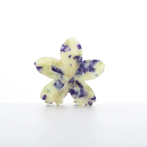 Star-shaped marble hair claw clip in purple and mint green with a glossy finish