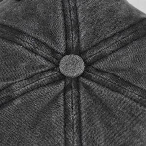Macro shot of the washed cotton fabric texture and top button of the charcoal baseball cap
