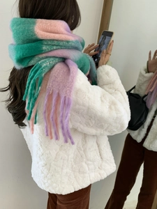Detail view of pink and purple rainbow plaid scarf with thick braided fringe tassels