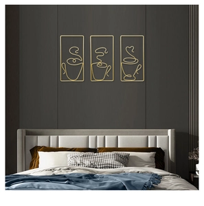 Close-up of three gold abstract metal wire coffee cup wall art pieces on a dark grey wall