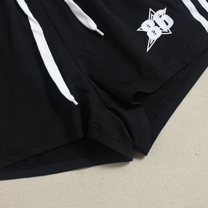 Detail der schwarzen Sportshorts mit weißen Kordelzügen und Stern-Grafikdruck