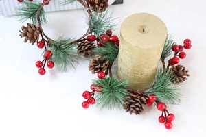 Makroansicht der Adventskranz-Kerzenhalter mit Piniennadeln, Zapfen und roten Beeren