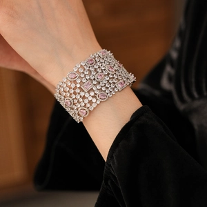 Detail of wide hollow bracelet featuring shimmering pink and white cubic zirconia stones