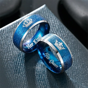 Primo piano di anelli di coppia blu con incisioni corona Her King e His Queen regalo