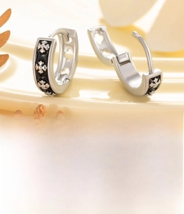 Vue macro des boucles d'oreilles croix argentées avec émail noir et diamètre de 9 mm