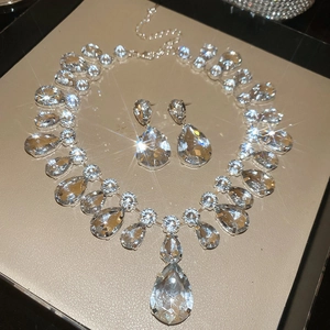 Detailed close-up of sparkling teardrop rhinestone necklace and earring bridal set