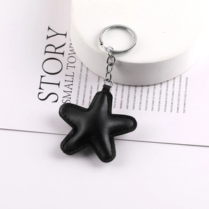 Vintage black PU leather star keychain with metal ring and chain on a white display stand