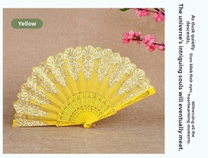 Yellow lace folding fan with intricate gold floral carving and baroque style fabric